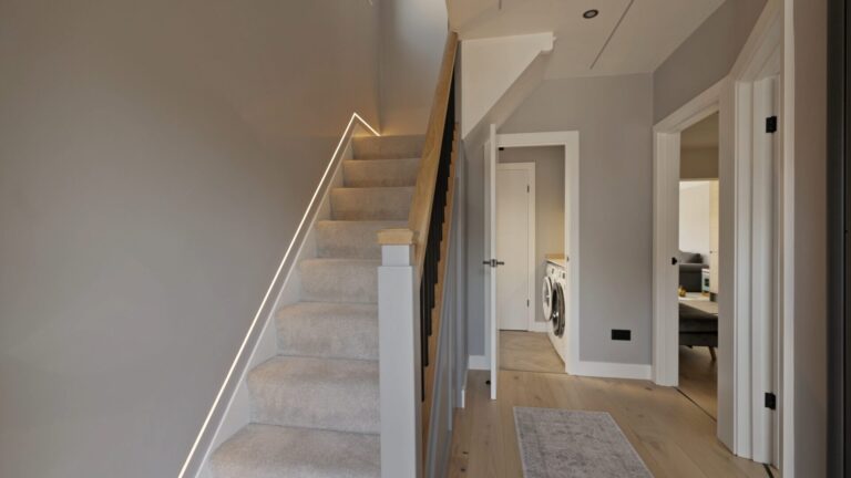 Staircase and landing after refurbishment, with pale carpet and wood flooring